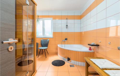 y baño con bañera y silla. en Awesome Home In Marcana With Jacuzzi, en Marčana
