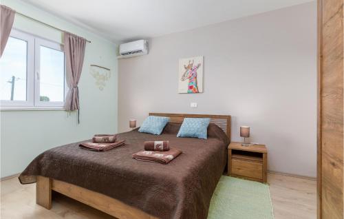 1 dormitorio con 1 cama grande y 2 almohadas en Awesome Home In Marcana With Jacuzzi, en Marčana