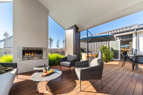 a living room with a fireplace on a deck at Nga Roto Retreat - Taupo in Taupo
