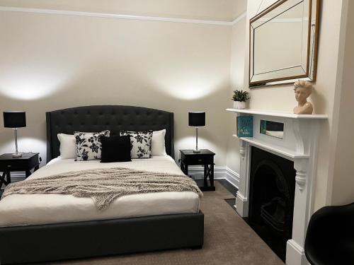 1 dormitorio con 1 cama con chimenea y espejo en Villa on Melbourne St en Adelaida