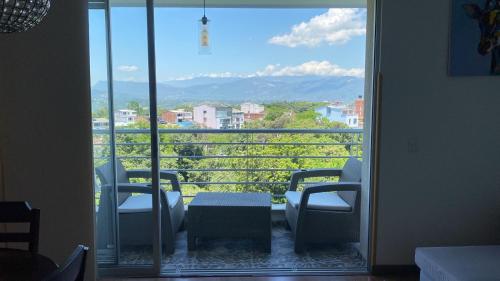 a room with a view of a balcony with chairs and a table at Disfruta Colombia!. in Bucaramanga