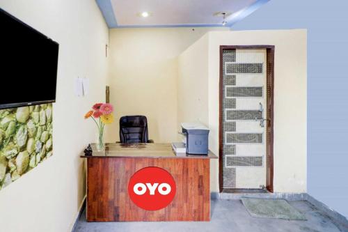 Habitación con escritorio y TV en la pared. en OYO Flagship 81042 Hotel Royal Inn en Manesar