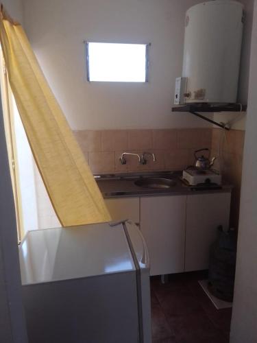 cocina con ventana, fregadero y encimera en Casa Flia Amarillo en Gualeguaychú