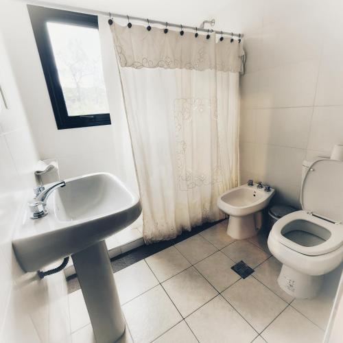 Baño blanco con lavabo y aseo en DelaIglesia en San Salvador de Jujuy