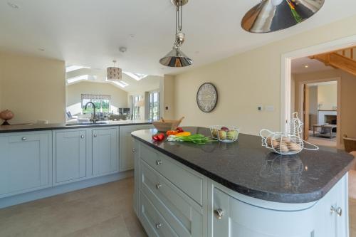 a kitchen with blue cabinets and a black counter top at Flint House W in Wighton