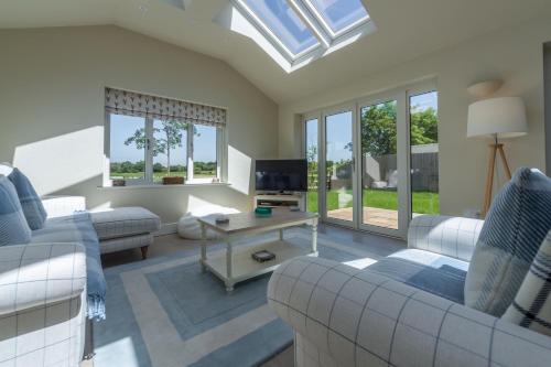 a living room with a couch and a table at Flint House W in Wighton