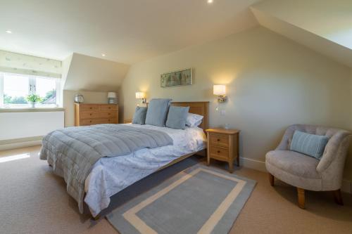 a bedroom with a large bed and a chair at Flint House W in Wighton