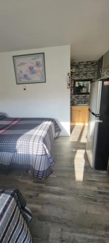 a kitchen with two beds and a refrigerator in a room at Southview Motel in Westlock