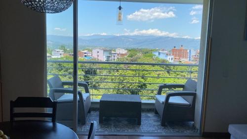 Zimmer mit einem großen Fenster mit Stühlen und Aussicht in der Unterkunft HABITACION DOBLE con baño compartido en apartamento compartido in Bucaramanga