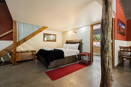 een slaapkamer met een bed en een trap in een huis bij Studio at Quins Gap Retreat in Bright