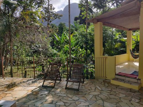 two chairs sitting on a patio with a gazebo at Chalés Bela Vista in Paraty