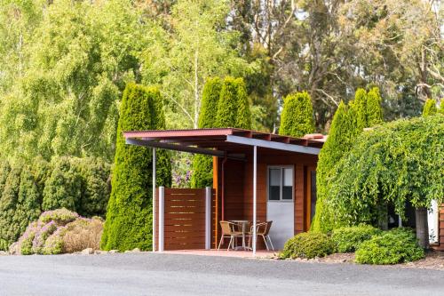 a small house with a porch with a table at Tall Timbers Tasmania in Smithton
