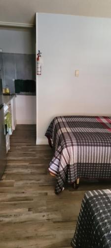 two beds in a room with wooden floors at Southview Motel in Westlock