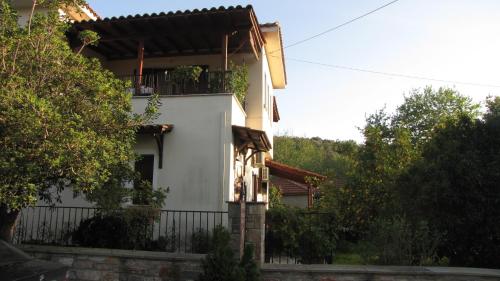 biały dom z płotem i drzewami w obiekcie Rafaela House w mieście Milina