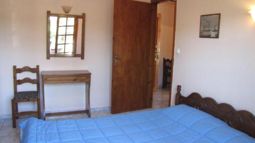 a bedroom with a bed and a desk and a window at Rafaela House in Milína