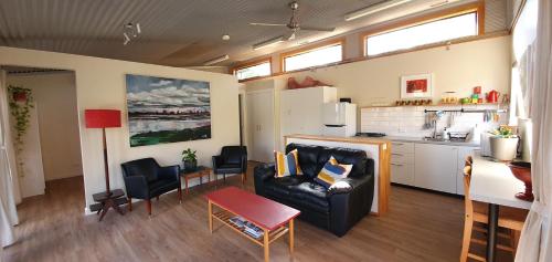 sala de estar con sofá y cocina en Studio Daruka, en Tamworth