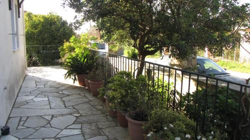a fence with potted plants on a sidewalk at Rafaela House in Milína