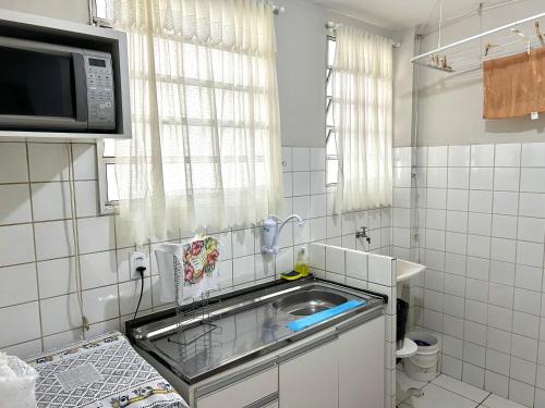 uma pequena cozinha com um lavatório e um micro-ondas em Apartamento mobiliado Piracicaba em Piracicaba