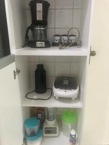 a kitchen shelf with a coffee maker and a blender at Apartamento mobiliado Piracicaba in Piracicaba