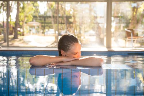 a young woman laying on the edge of a swimming pool at Tall Timbers Tasmania in Smithton