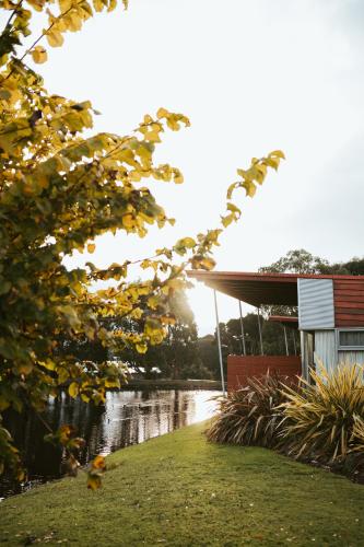 a house next to a body of water at Tall Timbers Tasmania in Smithton