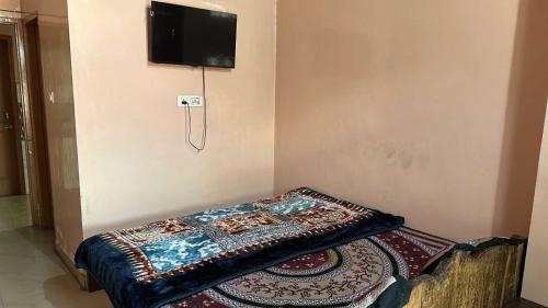 Una habitación con una cama con una manta. en OYO 81144 Royal Guest House, en Jīnd