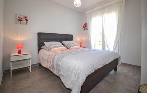 a bedroom with a large bed and a window at 2 Bedroom Amazing Home In Saint-ambroix in Saint-Ambroix