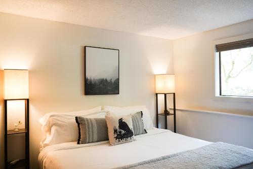 a bedroom with a white bed with two lamps at Mt Baker Den, Sleeps 4 in Glacier