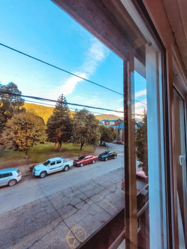 una vista desde una ventana de coches estacionados en una calle en Departamento Plaza en San Martín de los Andes