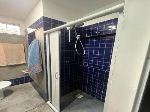 a bathroom with a shower with blue tiles at STUDIO 101 | WIFI 600MB | RESIDENCIAL JC, um lugar para ficar. in Belém
