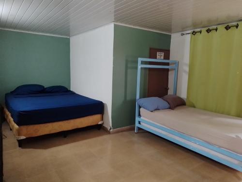 two beds in a room with green walls at CulturaHumana Guesthouse in Panama City