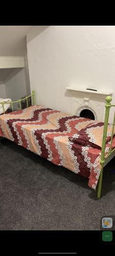 Bett in einem Zimmer mit einem Tisch und einer Tagesdecke in der Unterkunft 2 single bed in one room in a shared apartment in Bradford