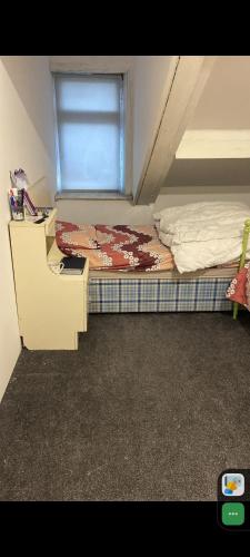 ein kleines Schlafzimmer mit einem Bett und einem Fenster in der Unterkunft 2 single bed in one room in a shared apartment in Bradford