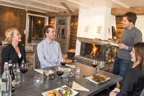 a group of people sitting around a table in a restaurant at Nordal Turistsenter in Lom