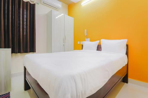 duże białe łóżko w pokoju z pomarańczową ścianą w obiekcie Home Sri Balaji Luxary Rooms Near Inorbit Mall Cyberabad w mieście Gachibowli