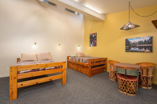um quarto com 2 camas, uma mesa e cadeiras em Falcons Nest (Upstairs) em Yosemite West