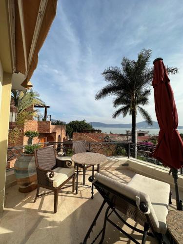 a patio with a table and chairs and a palm tree at Hotel Lindo Ajijic Bed & Breakfast in Ajijic