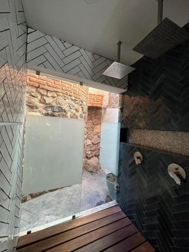 a bathroom with a shower with a stone wall at Hotel Lindo Ajijic Bed & Breakfast in Ajijic