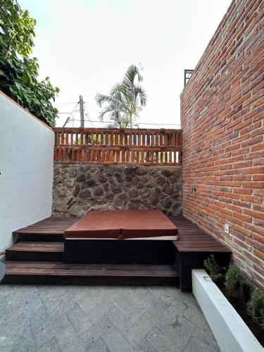 a wooden bench sitting next to a brick wall at Hotel Lindo Ajijic Bed & Breakfast in Ajijic