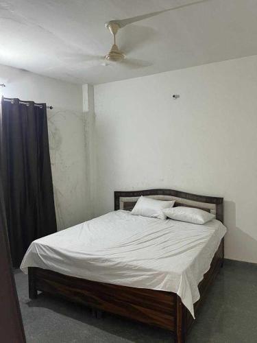 een bed in een slaapkamer met een plafond bij OYO Home R K Oyo Hotel in Noida