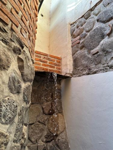 a corner of a room with a stone wall at Hotel Lindo Ajijic Bed & Breakfast in Ajijic