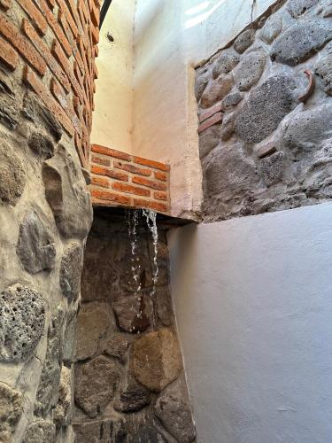 a corner of a stone wall with water dripping from it at Hotel Lindo Ajijic Bed & Breakfast in Ajijic
