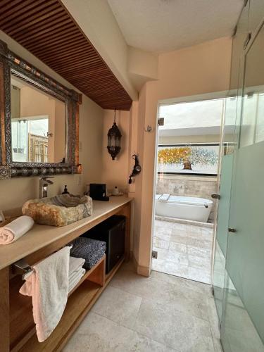 a bathroom with a tub and a sink and a mirror at Hotel Lindo Ajijic Bed & Breakfast in Ajijic