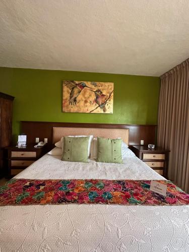 a bedroom with a large bed with green walls at Hotel Lindo Ajijic Bed & Breakfast in Ajijic