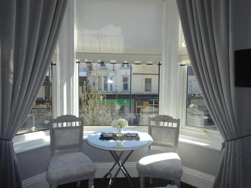 a table and chairs in a room with a window at Elmswood Guest House in South Shields