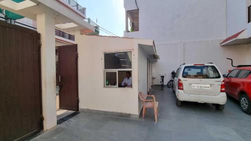 a small white car parked next to a building at Spot ON HOME 81265 Hotel Sitasmriti in Phāphāmau