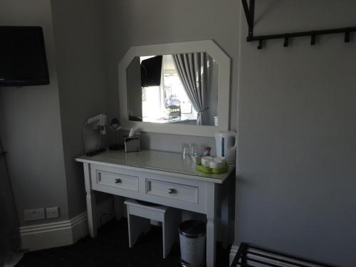 a bathroom with a white sink and a mirror at Elmswood Guest House in South Shields