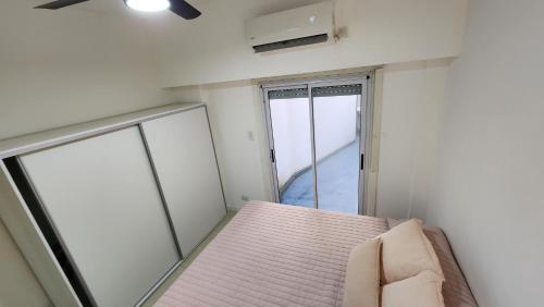 Habitación pequeña con cama y ventana en Confortable departamento amoblado de 2 ambientes en RECOLETA con patio en Buenos Aires