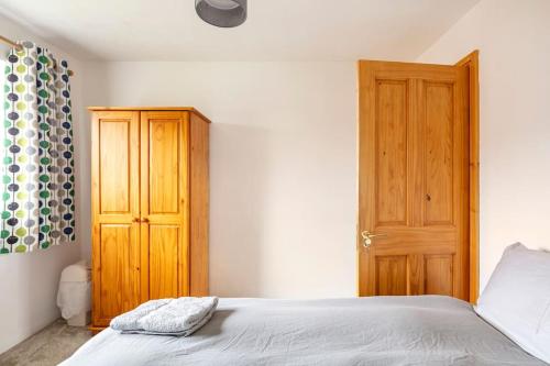 1 dormitorio con 1 cama y puerta de madera en Double Room, Large TV, With Great Transport Links en Bolton