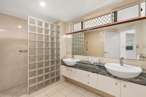a bathroom with two sinks and a mirror at Arlington Apartments in Clifton Beach
